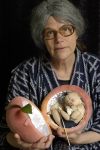 Obasan
                      holds the peach and Momotaro emerges